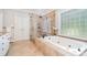 Elegant bathroom featuring a soaking tub and large glass enclosed shower with multi-head fixtures at 5537 Challis View Ln, Charlotte, NC 28226