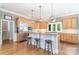 Eat-in kitchen with stainless steel appliances, light wood cabinets, granite countertops, and barstool seating at 5537 Challis View Ln, Charlotte, NC 28226