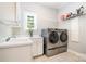 Well-lit laundry room equipped with modern washer and dryer, utility sink, and shelving at 5537 Challis View Ln, Charlotte, NC 28226