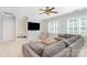 Cozy living room with a large sectional sofa, built-in bookshelves, and a ceiling fan at 5537 Challis View Ln, Charlotte, NC 28226