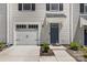 Close up of a townhome featuring a garage door, front door, and small shrubbery in front at 5690 Granbury Dr, Kannapolis, NC 28081