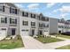 View of gray siding townhomes with driveways, sidewalks, and a small grassy area in front at 5690 Granbury Dr, Kannapolis, NC 28081