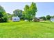 Large grassy backyard featuring multiple storage sheds and mature trees at 701 Mcswain Rd, Shelby, NC 28150