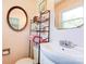 A bathroom featuring a sink and a toilet with decorative accents and storage shelving at 701 Mcswain Rd, Shelby, NC 28150