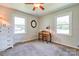 A bright bedroom featuring two windows, carpet, and a desk with a lamp for study at 701 Mcswain Rd, Shelby, NC 28150