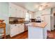 Well-lit kitchen with white cabinets, center island, and vintage-style backsplash at 701 Mcswain Rd, Shelby, NC 28150