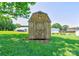 Wooden storage shed with a barn-style roof in a grassy backyard, providing ample outdoor storage at 701 Mcswain Rd, Shelby, NC 28150
