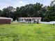 A well-maintained home surrounded by a beautiful green lawn and complemented by dense trees at 7010 Executive Cir, Denver, NC 28037