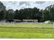 A charming home with a carport and white picket fence, with green lawn and lush trees at 7010 Executive Cir, Denver, NC 28037