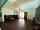 Open living room featuring a ceiling fan, dark wood floors, and a leather sofa at 7010 Executive Cir, Denver, NC 28037