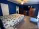 Spacious main bedroom with closet and dresser. Includes an ensuite bath and plush blue walls at 7010 Executive Cir, Denver, NC 28037