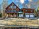 Beautiful lakefront cabin featuring stone accents, a three-car garage, patio, and upper and lower decks at 720 Potneck Rd, Salisbury, NC 28147