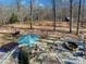 Outdoor living area featuring stone patio, fire pit, umbrella, and wooded views at 720 Potneck Rd, Salisbury, NC 28147