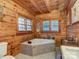 Bathroom featuring a soaking tub, wooden walls and floors, and natural lighting at 720 Potneck Rd, Salisbury, NC 28147