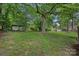 Lush green backyard with scattered sheds and a mature shade tree at 807 Claremont Rd, Charlotte, NC 28214