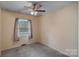 A simple bedroom with neutral walls, carpet, and a ceiling fan providing a basic and functional space at 807 Claremont Rd, Charlotte, NC 28214