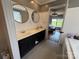 Bathroom with double vanity, round mirrors, neutral walls, and a glimpse of the bedroom beyond at 8122 Hutchison Ln, Vale, NC 28168