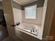 A very clean and bright bathroom featuring a jetted tub with white tile surround at 8122 Hutchison Ln, Vale, NC 28168