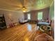 Spacious bedroom with two beds, wood floors, ceiling fan, and charming decorations at 8122 Hutchison Ln, Vale, NC 28168