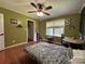 This is a bright bedroom with wood floors, ceiling fan and window views at 8122 Hutchison Ln, Vale, NC 28168