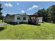 Well-maintained home exterior with a deck, shed, and spacious yard, offering ample outdoor space at 8122 Hutchison Ln, Vale, NC 28168