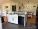 Spacious kitchen with a farmhouse sink, modern dishwasher, and a view into the bright dining area at 8122 Hutchison Ln, Vale, NC 28168