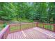 View of wood deck with wooden railing surrounded by lush green trees at 9000 Vagabond Rd, Charlotte, NC 28227