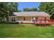 Expansive backyard with a wooden deck, green grass, and mature trees at 9000 Vagabond Rd, Charlotte, NC 28227