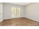 Bright bedroom with wood-look flooring, neutral walls, and large windows offering natural light at 9000 Vagabond Rd, Charlotte, NC 28227