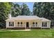 Charming single story home featuring a welcoming front porch, well-manicured lawn, and mature trees at 9000 Vagabond Rd, Charlotte, NC 28227