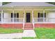 Covered front porch with brick foundation and black front door at 9000 Vagabond Rd, Charlotte, NC 28227