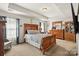 Spacious main bedroom featuring tray ceilings, carpet, and wooden furniture at 9511 Turning Wheel Dr, Charlotte, NC 28214