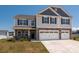 Charming two-story home with a three car garage, gray siding and beautiful stone accents at 9529 Cotswood Pl, Gastonia, NC 28056
