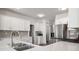 Bright kitchen featuring stainless appliances, white cabinets and countertops and breakfast bar at 9529 Cotswood Pl, Gastonia, NC 28056