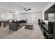Spacious living room featuring a large gray sofa, modern entertainment center, and a billiards table at 9529 Cotswood Pl, Gastonia, NC 28056