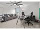 Bright home office with a modern desk, comfy sofa, and a large ceiling fan, perfect for productivity at 9529 Cotswood Pl, Gastonia, NC 28056