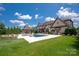 An expansive backyard featuring a pool, fireplace, outdoor kitchen, and manicured lawn at 11008 Strike The Gold Ln, Waxhaw, NC 28173