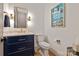Modern powder room with navy vanity, gold fixtures, and decorative accents at 11008 Strike The Gold Ln, Waxhaw, NC 28173