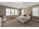 Cozy bedroom with neutral tones, plush carpet, and a decorative chandelier for soft, ambient lighting at 11008 Strike The Gold Ln, Waxhaw, NC 28173