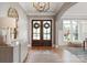 Elegant foyer featuring hardwood floors, a decorative mirror, and double doors with wreath accents at 11008 Strike The Gold Ln, Waxhaw, NC 28173