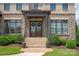 Close-up of the stately front entrance with beautiful double doors and manicured landscaping at 11008 Strike The Gold Ln, Waxhaw, NC 28173