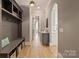 Hallway with dark gray walls, wood floors and a bench with hooks and an arched doorway at 11008 Strike The Gold Ln, Waxhaw, NC 28173