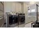Bright laundry room with modern washer and dryer, stylish cabinets, and unique tile backsplash at 11008 Strike The Gold Ln, Waxhaw, NC 28173