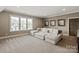 Cozy living room featuring a large sectional sofa, plush carpeting, and bright natural light at 11008 Strike The Gold Ln, Waxhaw, NC 28173