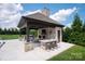 Outdoor kitchen with bar seating, fireplace, and built-in grill is an entertainer's dream at 11008 Strike The Gold Ln, Waxhaw, NC 28173