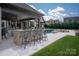 An outdoor living space features bar seating, a pool, and a fire pit for entertaining at 11008 Strike The Gold Ln, Waxhaw, NC 28173