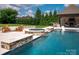 Backyard pool with hot tub and outdoor lounge is perfect for relaxing and entertaining guests at 11008 Strike The Gold Ln, Waxhaw, NC 28173