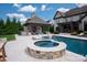 A pool and spa is enhanced by an outdoor living space in this elegant backyard retreat at 11008 Strike The Gold Ln, Waxhaw, NC 28173