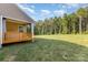 Expansive backyard featuring a manicured lawn, mature trees, and a covered deck at 11226 Dappled Light Trl, Charlotte, NC 28227