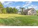Spacious backyard featuring lush green grass, wooden decks, mature trees, and fenced perimeter on a sunny day at 11226 Dappled Light Trl, Charlotte, NC 28227